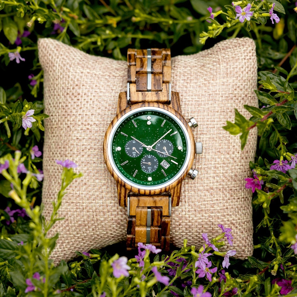 Mokozai wooden watch with a green dial, displayed on a natural linen pillow, surrounded by lush greenery and small purple flowers. The watch’s eco-friendly wooden strap and luxurious design appeal to nature lovers and stylish individuals in Australia who appreciate sustainability and elegance.