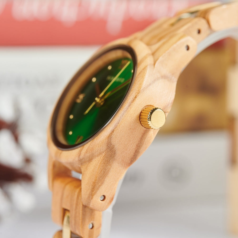 Close-up view of Mokozai women's wooden watch, showcasing its polished gold crown and natural wood grain texture. The green dial adds a vibrant contrast to the light wood casing, emphasizing eco-friendly luxury for fashion-forward, sustainable accessory enthusiasts in Australia.