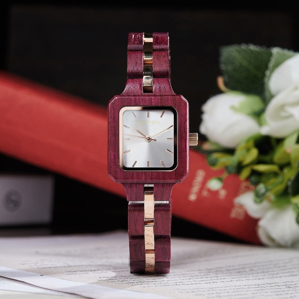Mokozai square wooden watch with purple wood and gold accents, featuring a silver dial and minimalist markers. The refined design is set against a backdrop of books and flowers, symbolizing elegance and sophistication for style-focused eco-conscious individuals in Australia.