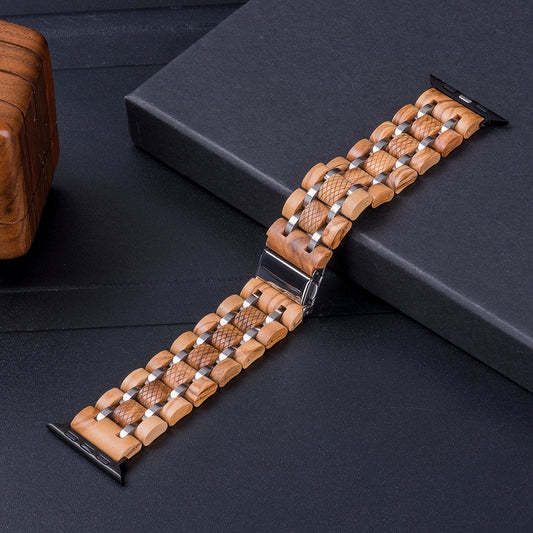 Light wooden watch band with silver metal accents and a textured design, displayed on a black surface with wooden packaging in the background.