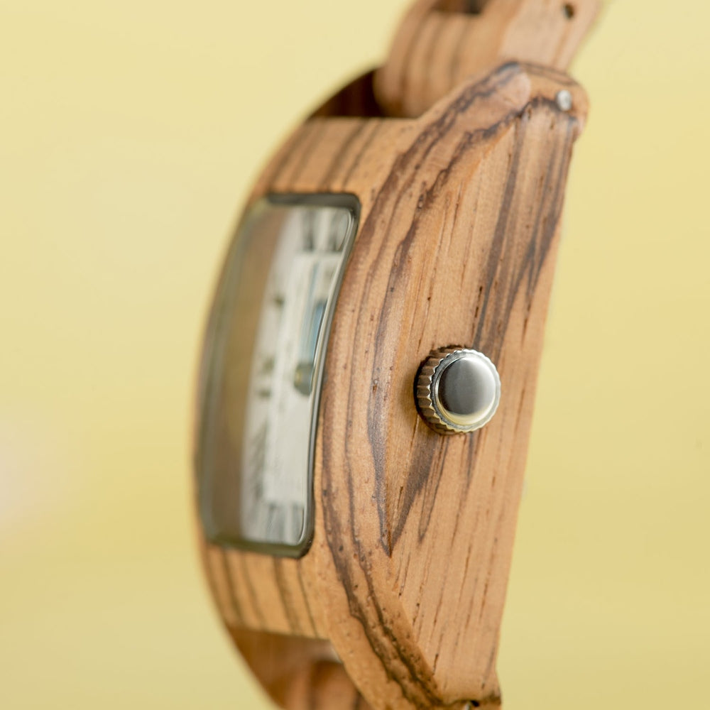 Close-up of the side profile of a Mokozai wooden wristwatch, highlighting the natural wood grain and metallic crown on a light yellow background. The finely crafted wooden case offers a seamless blend of classic elegance and modern sustainability for fashion-conscious individuals in Australia.
