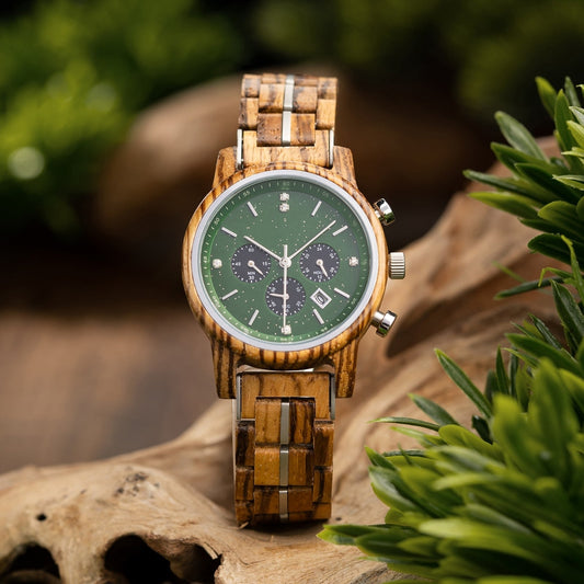 Mokozai men's wooden chronograph watch featuring a natural wood grain strap, green dial with subdials, and diamond accents, beautifully displayed against a rustic wooden background with vibrant greenery. This eco-friendly luxury timepiece merges organic materials with refined craftsmanship, ideal for nature-conscious customers in Australia.