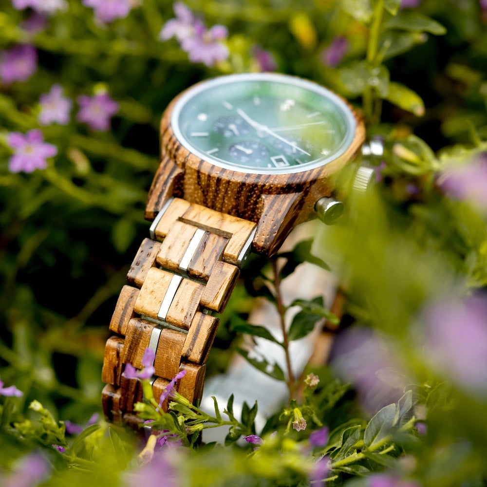 Mokozai wooden watch nestled in vibrant greenery and small purple flowers, highlighting the eco-friendly design and natural wood grain strap. The green dial complements the lush natural surroundings, appealing to eco-conscious customers in Australia who value sustainability and style.