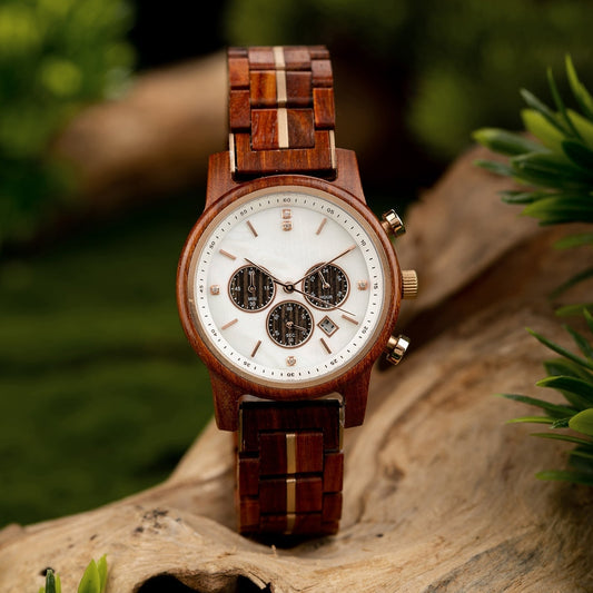 Mokozai wooden wristwatch featuring a sleek white dial with rose gold accents and three subdials for day, date, and 24-hour time. The rich wooden band with subtle inlaid stripes complements the natural design, blending elegance and sustainability. Set against a nature-inspired backdrop, this watch exudes eco-luxury and precision.
