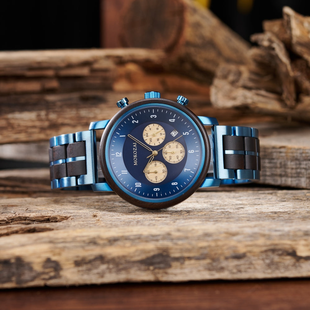 Mokozai luxury watch featuring a blue dial with golden subdials and a polished blue metal and dark wood strap, elegantly displayed against a rustic wooden background, blending modern style with natural elements.