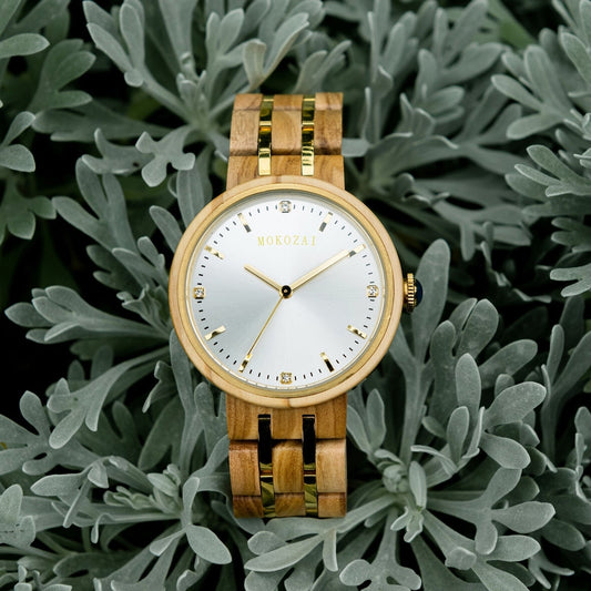 Mokozai luxury wooden watch with a sleek white dial and gold accents, nestled in soft greenery. A sustainable, eco-friendly timepiece crafted from natural wood, perfect for eco-conscious Australians seeking elegant and stylish accessories.